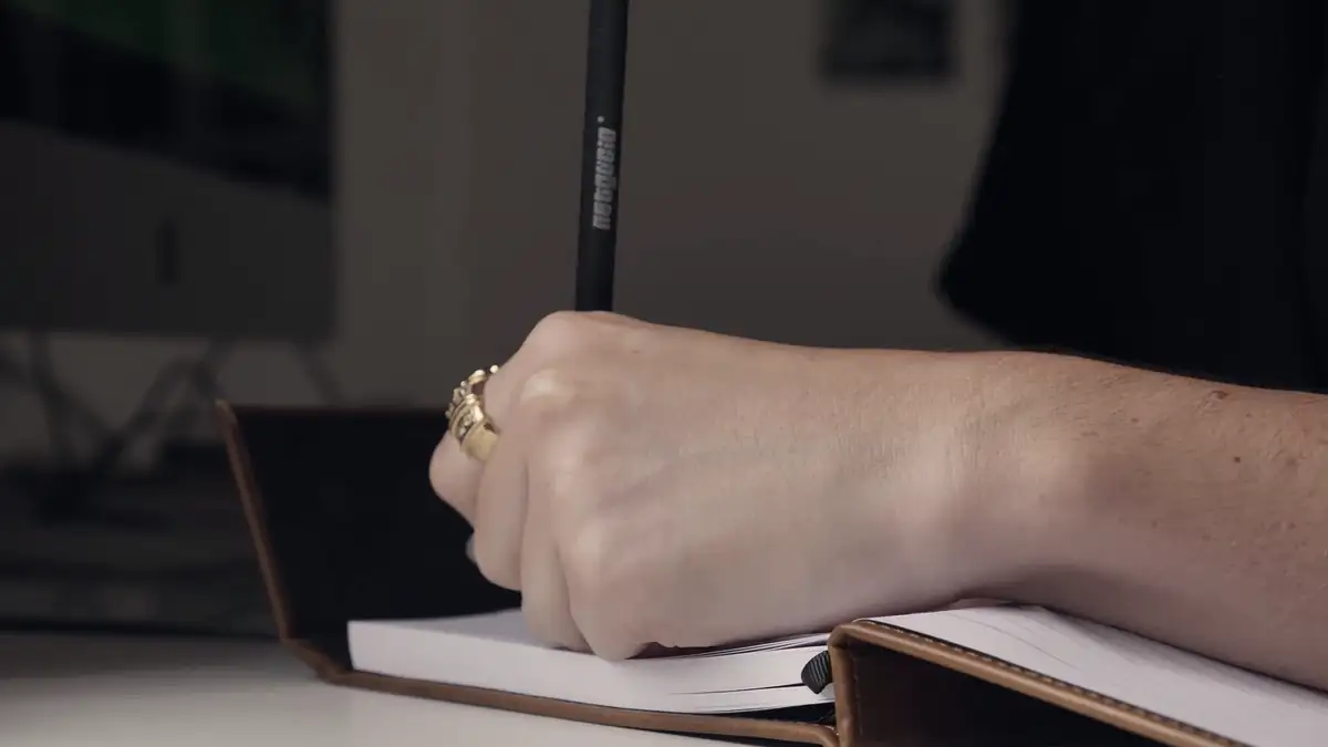 A hand writing in a notebook
