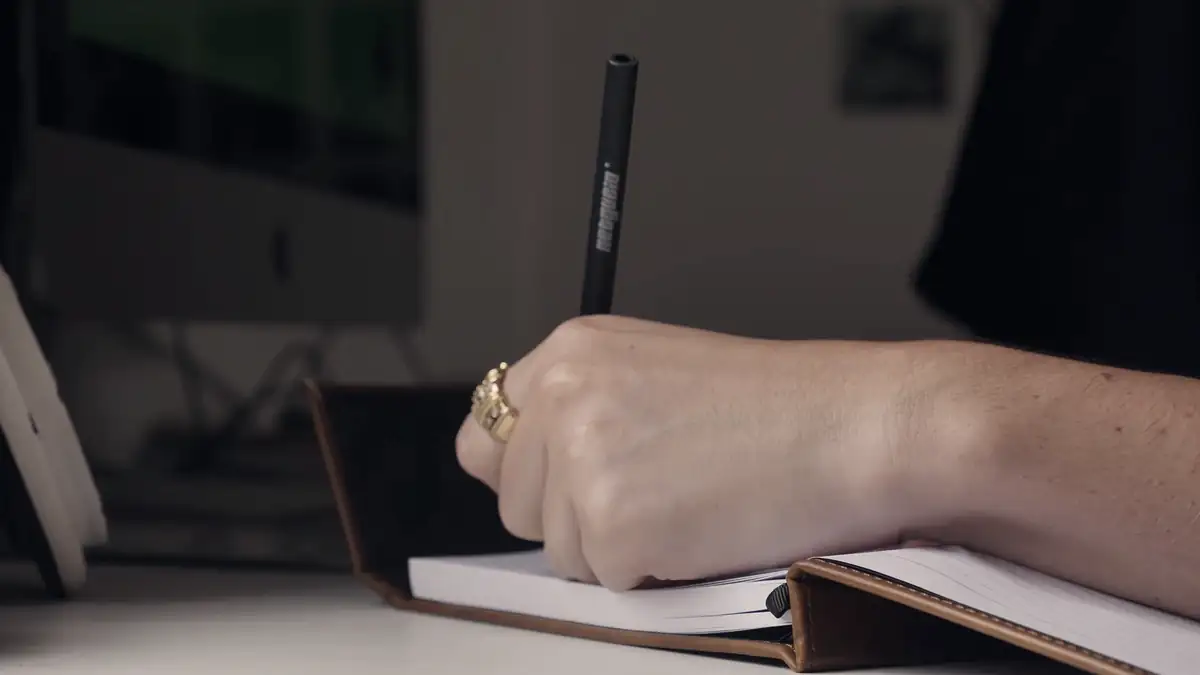 A hand writing in a notebook