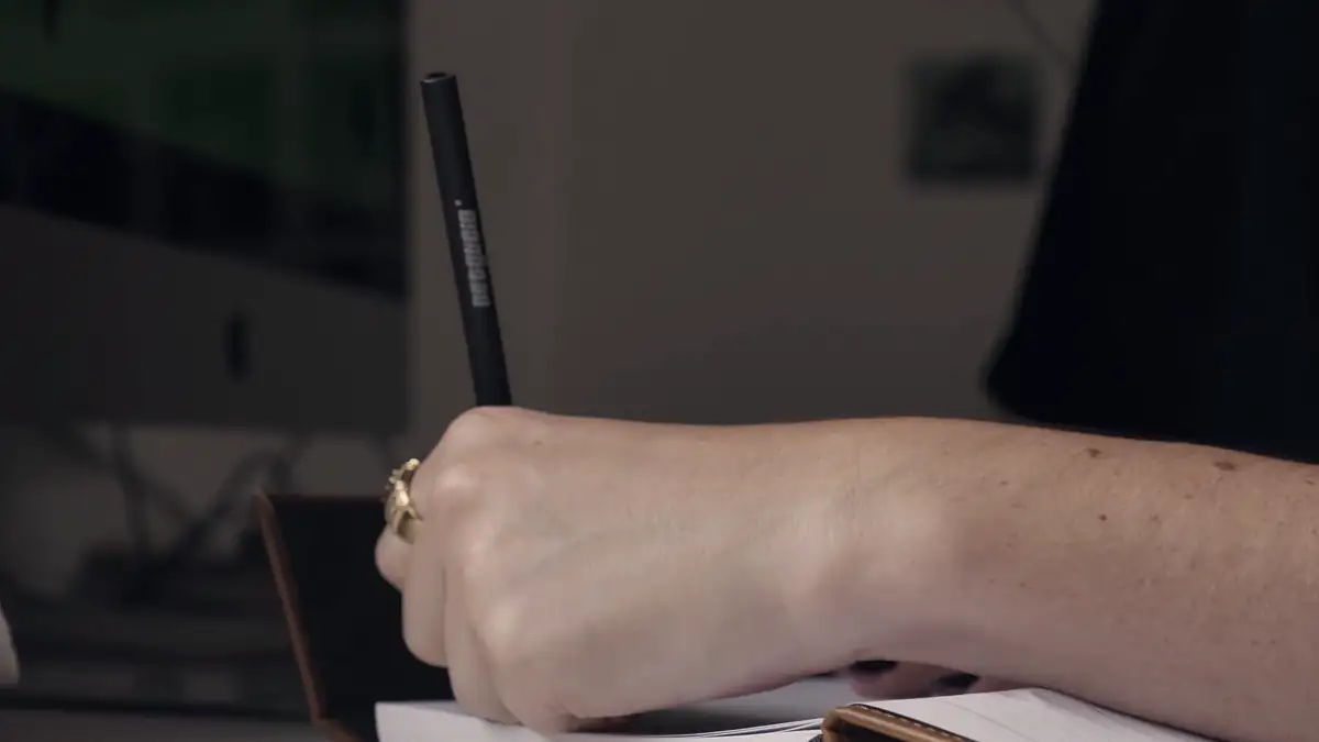 A hand writing in a notebook
