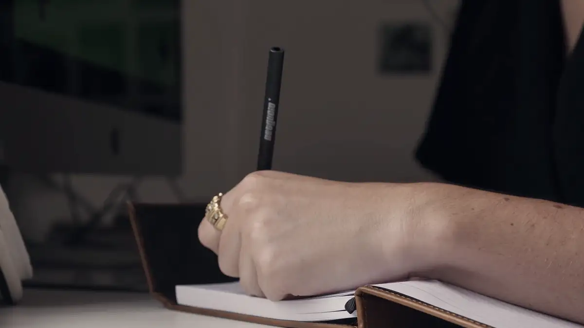 A hand writing in a notebook