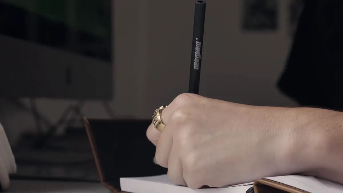 A hand writing in a notebook
