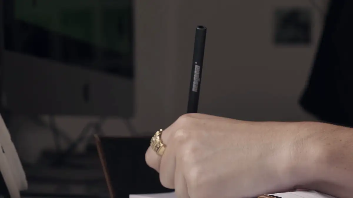 A hand writing in a notebook