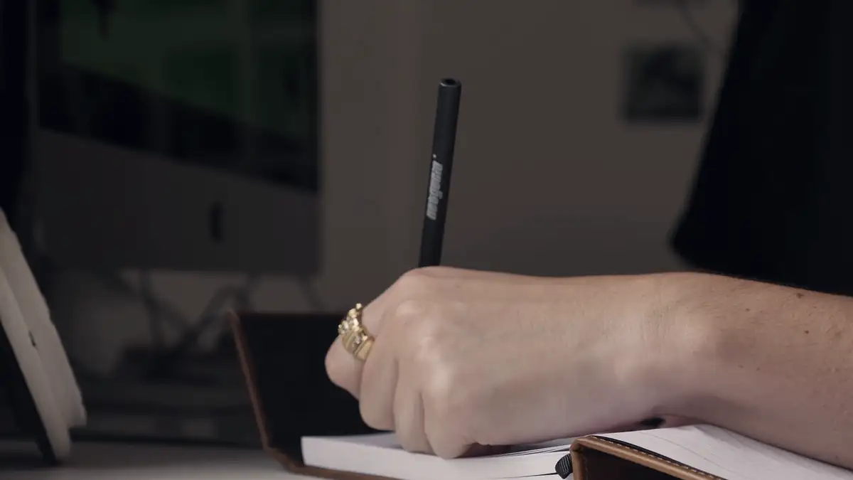 A hand writing in a notebook
