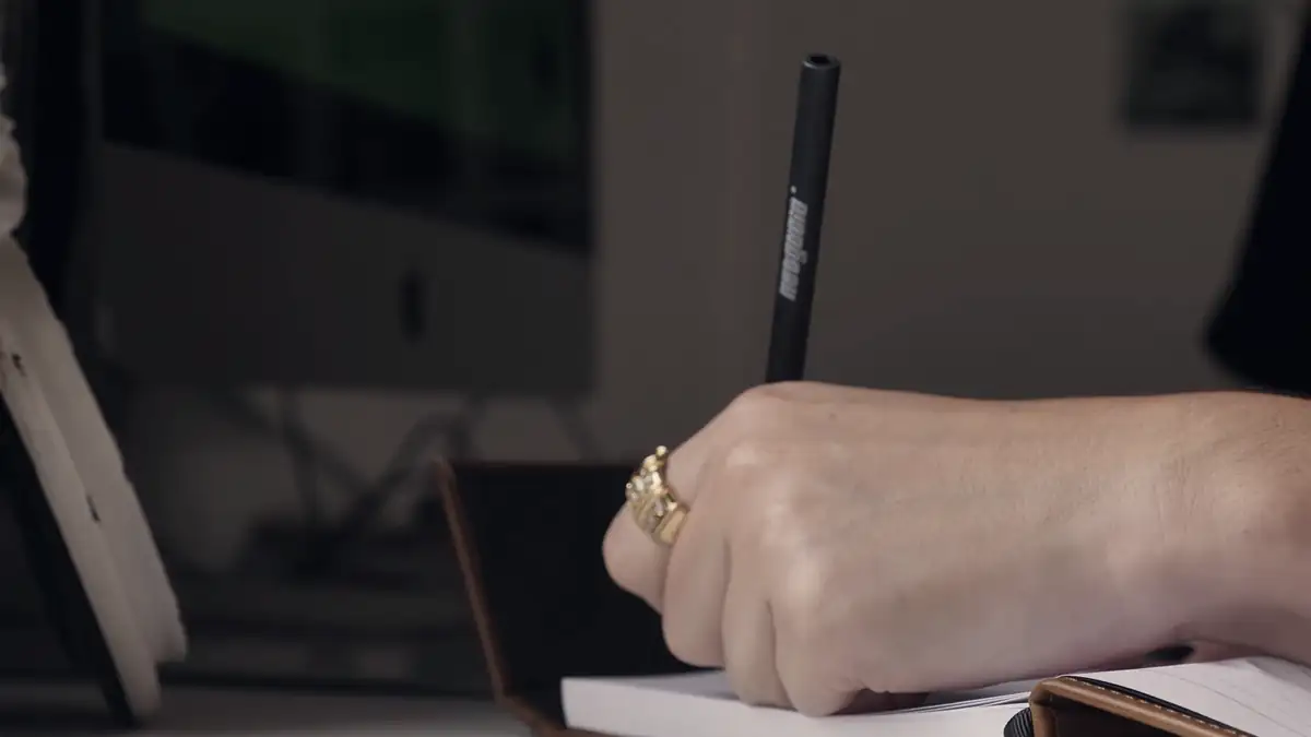 A hand writing in a notebook