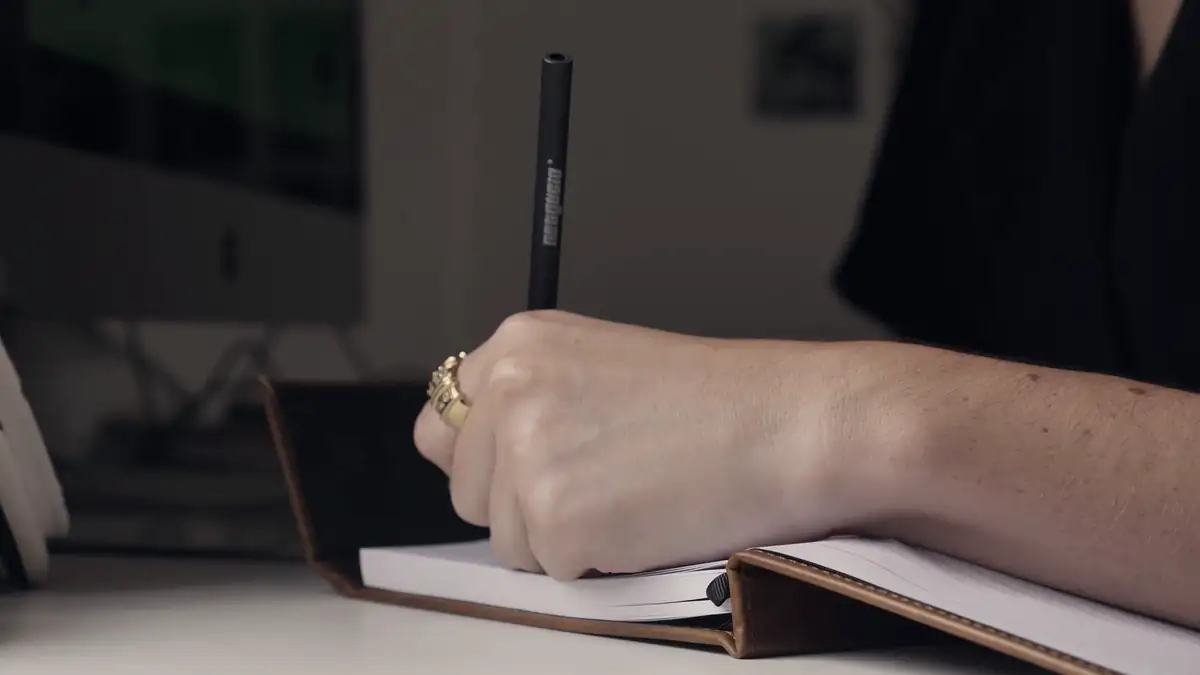 A hand writing in a notebook