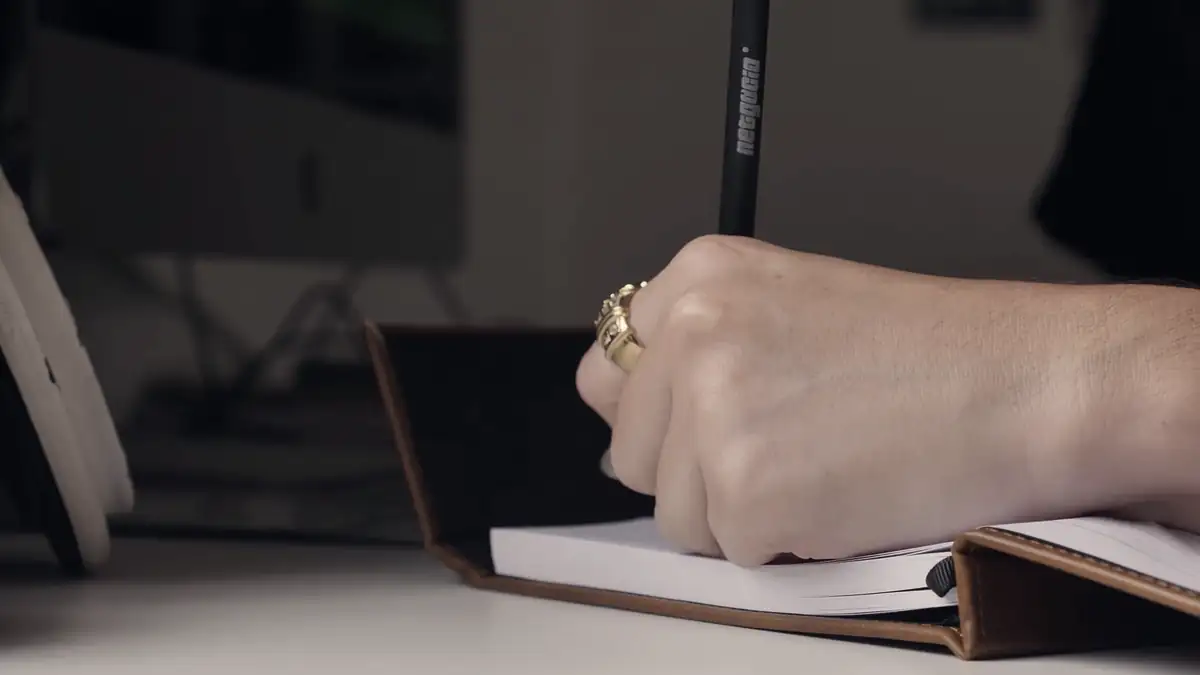 A hand writing in a notebook
