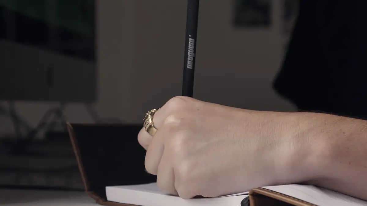 A hand writing in a notebook