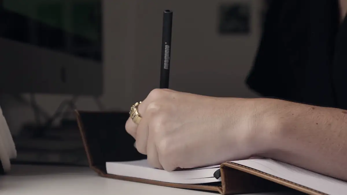 A hand writing in a notebook