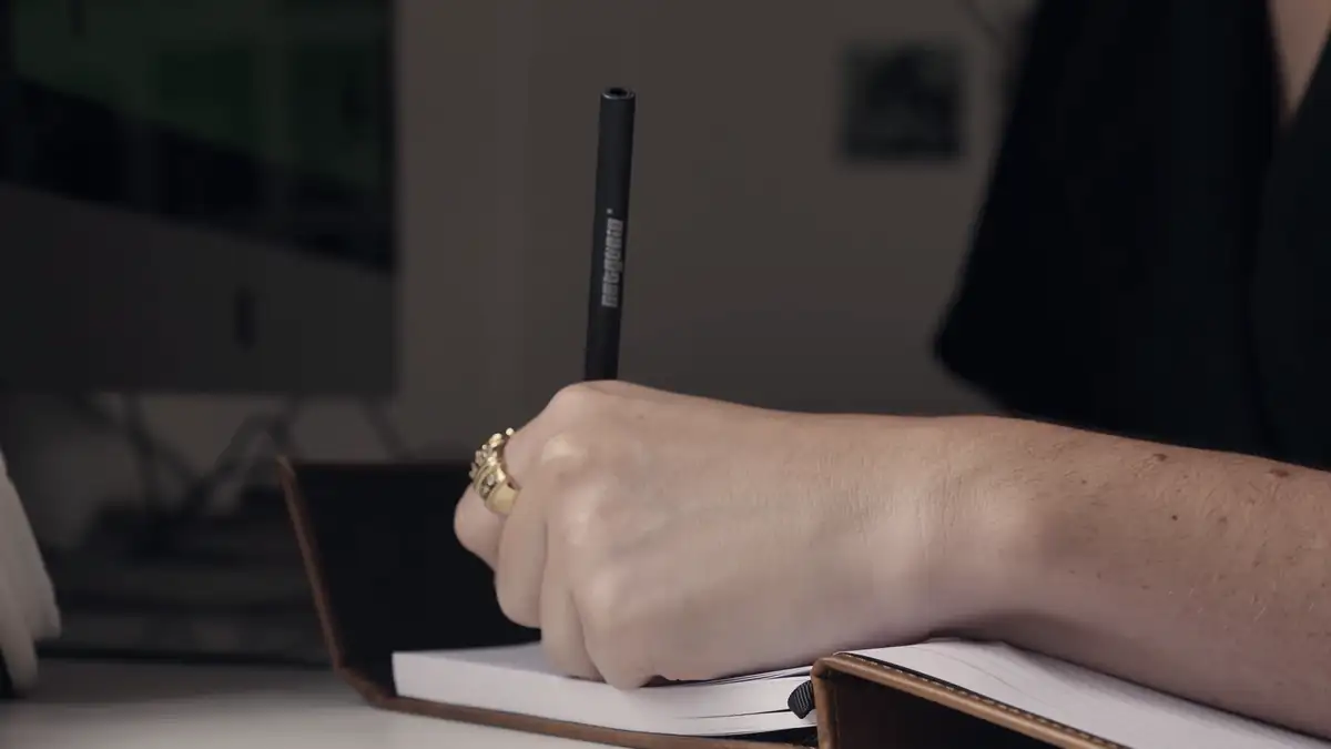 A hand writing in a notebook