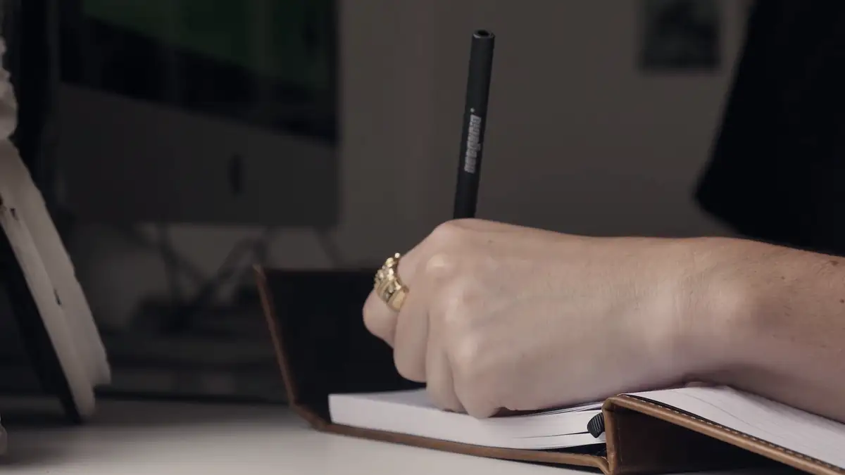 A hand writing in a notebook