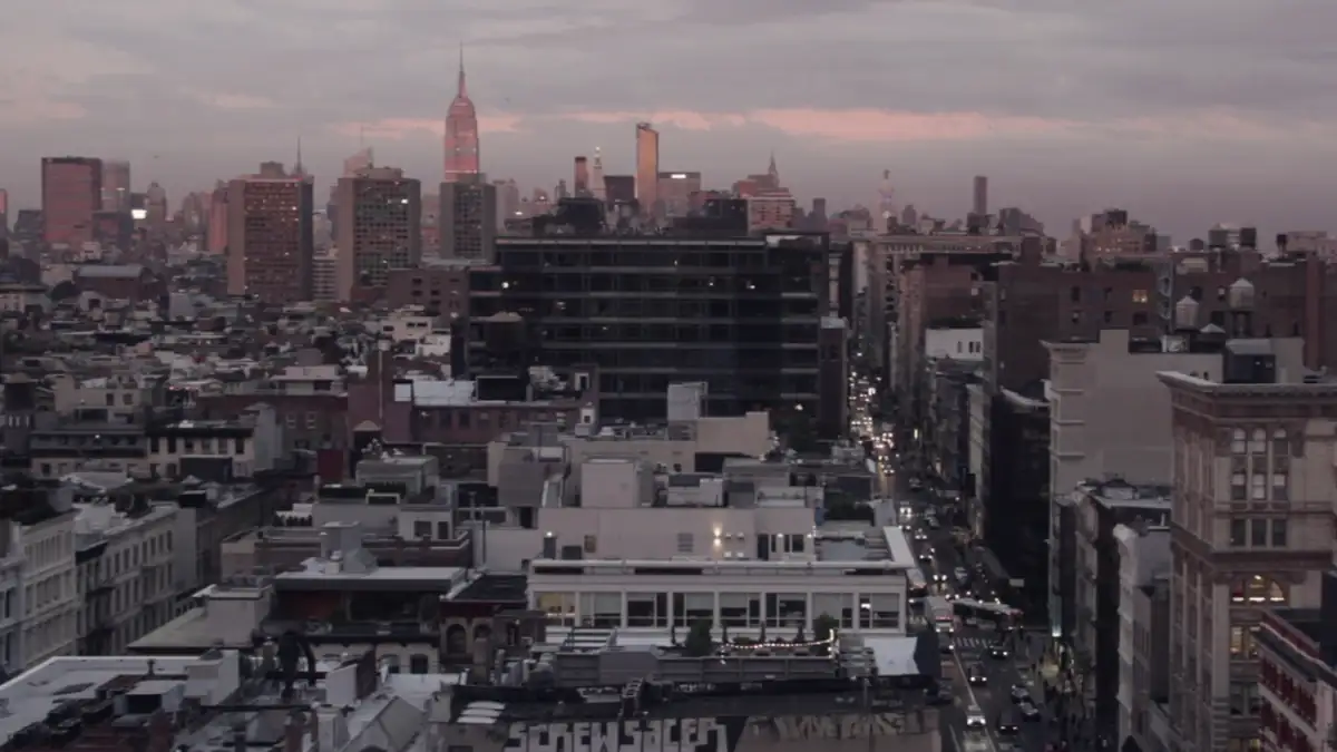 City rooftops under a pink sunset sky