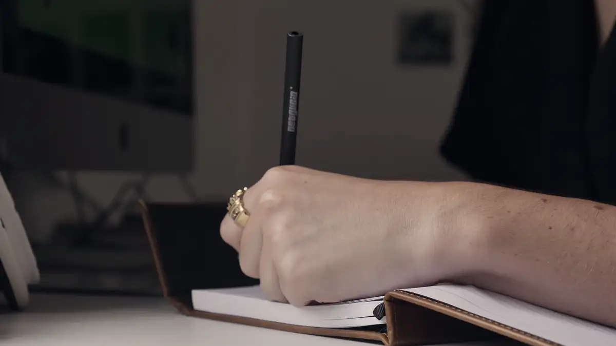 A hand writing in a notebook