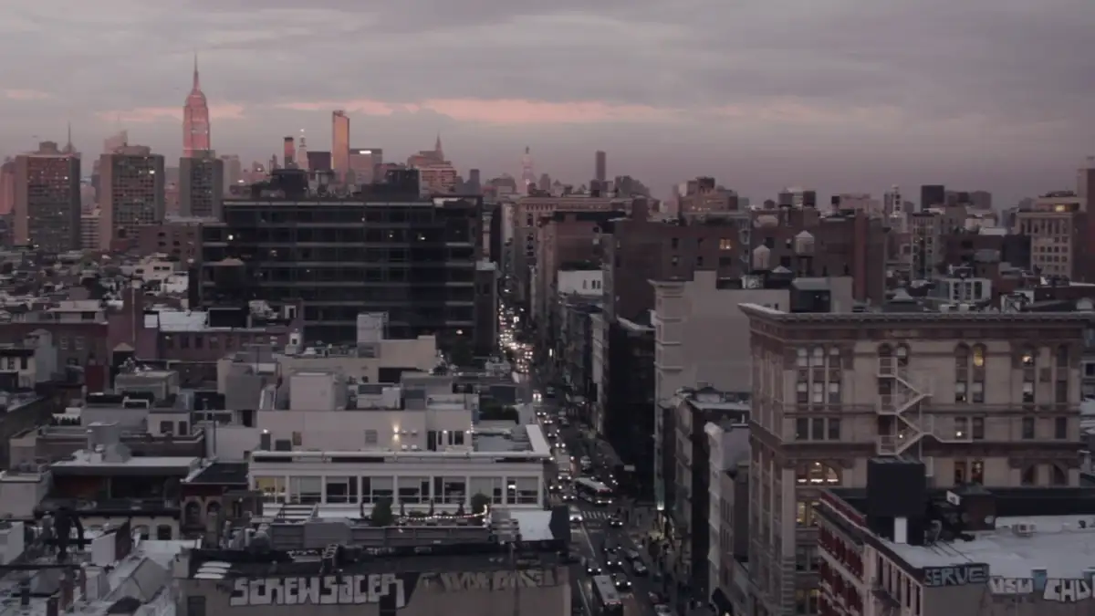 City rooftops under a pink sunset sky