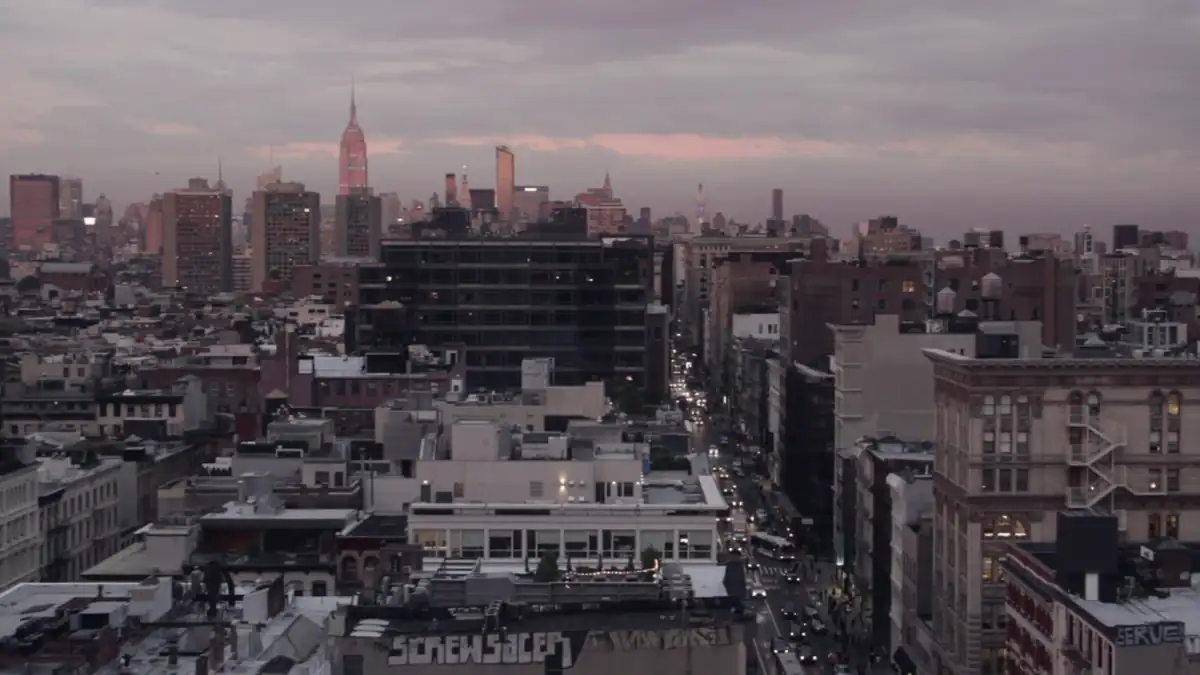 City rooftops under a pink sunset sky