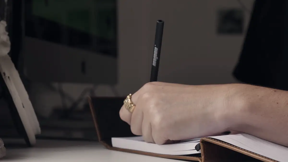 A hand writing in a notebook