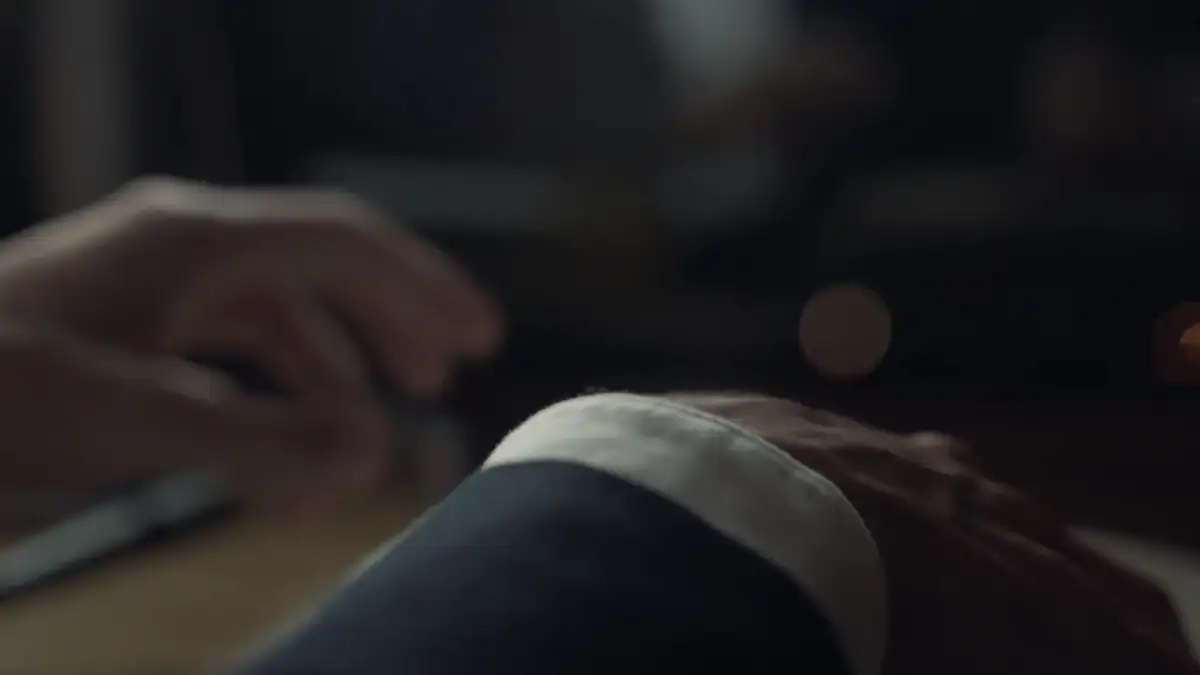 Hands turning the pages of a notebook in low light