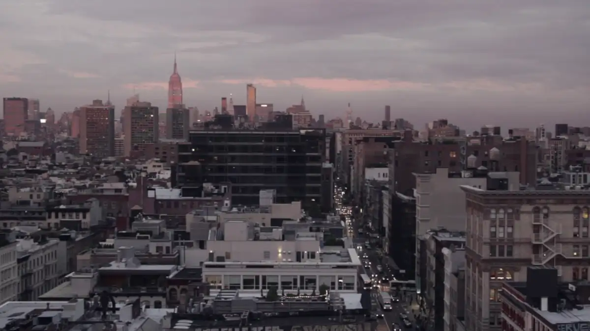 City rooftops under a pink sunset sky