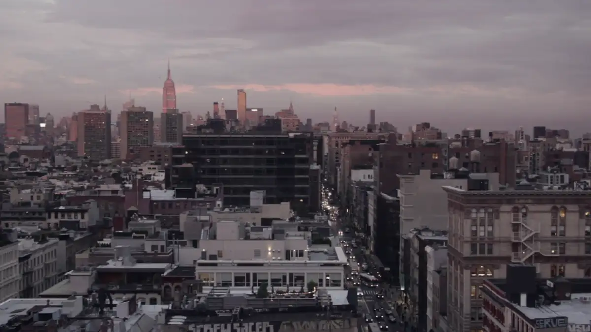 City rooftops under a pink sunset sky